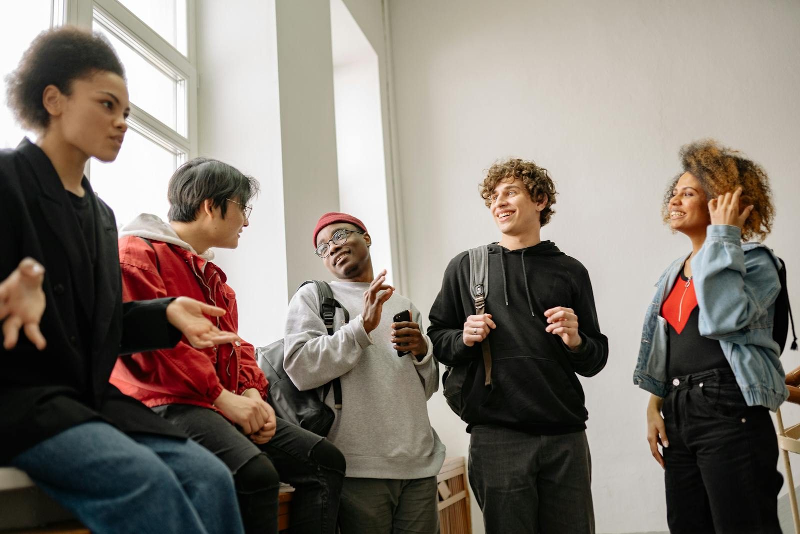 A lively group of diverse students chatting and interacting indoors.