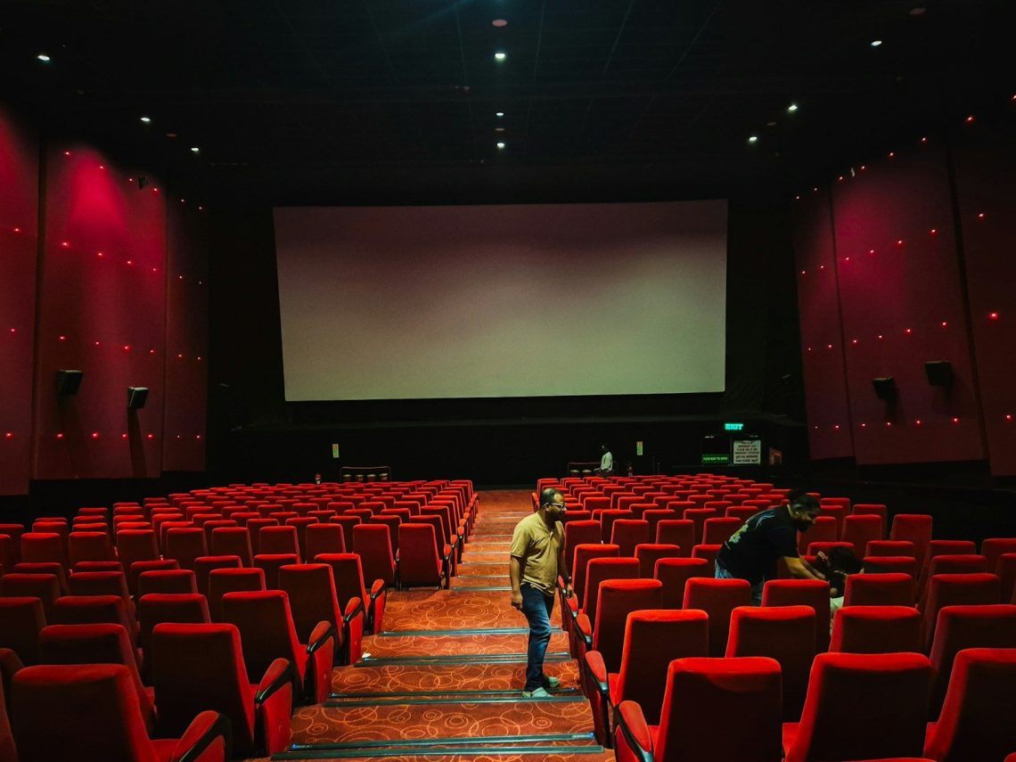 Empty cinema hall with red seats and large screen