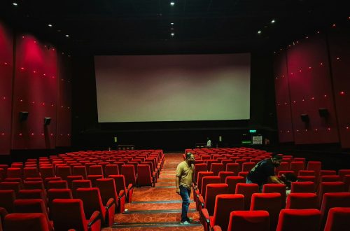 Empty cinema hall with red seats and large screen