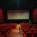 Empty cinema hall with red seats and large screen